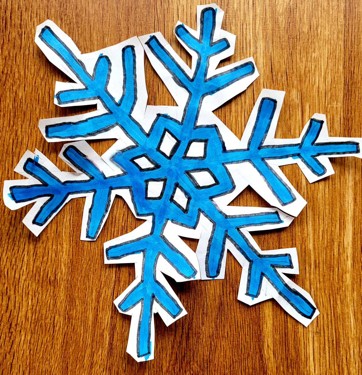 Drawing of a blue snowflake cut out.