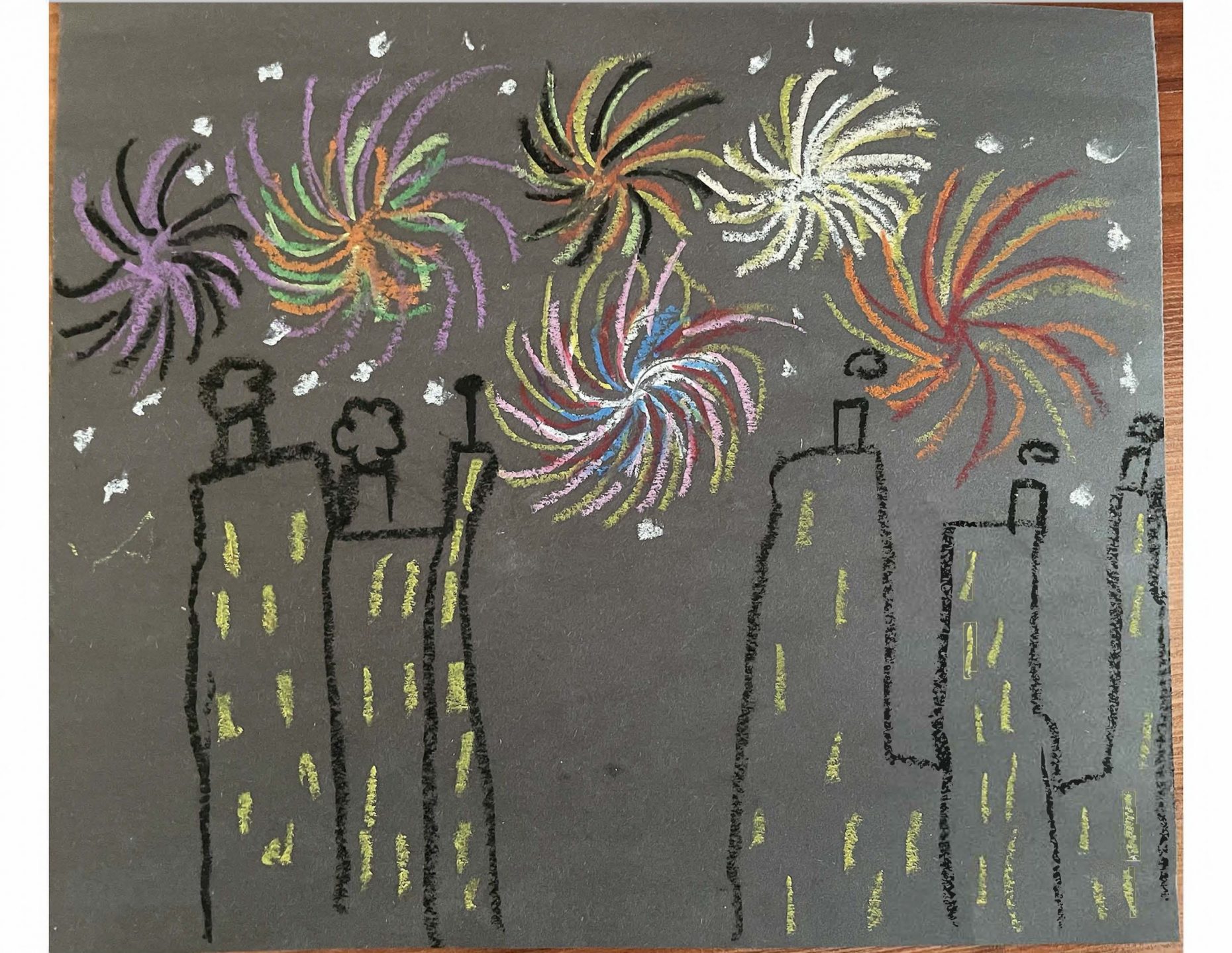 Chalk drawing of city skyline with fireworks in the sky.