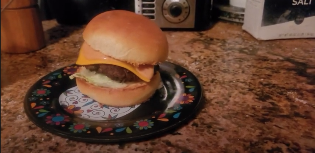Cheeseburger with melted cheese on a toasted bun.