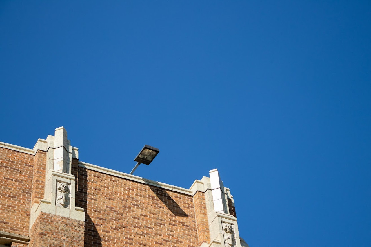 a photograph of the top of a building set against a clear blue sky