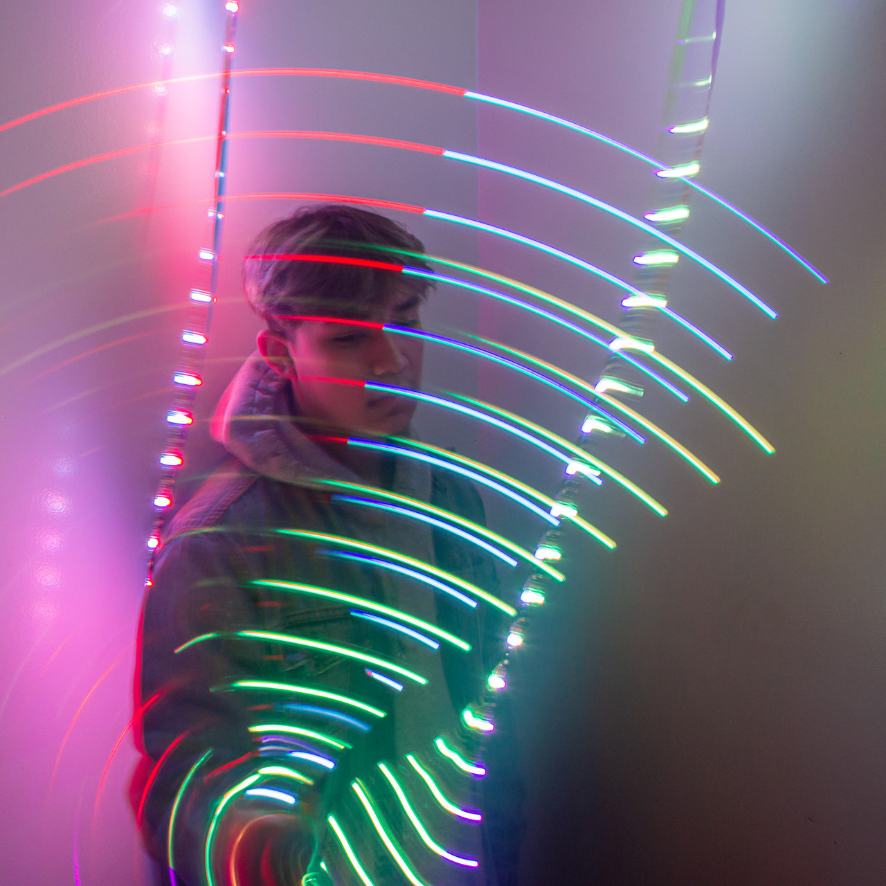 photograph of a young person behind a wall of colorful light