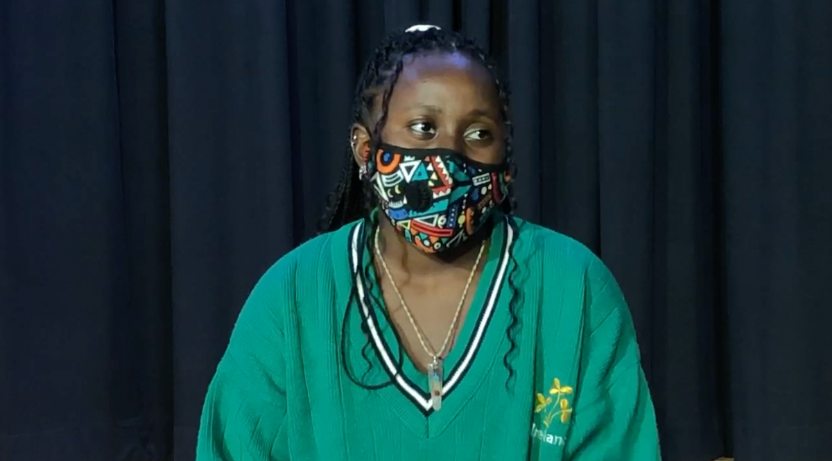 Person with a green shirt and colorful mask