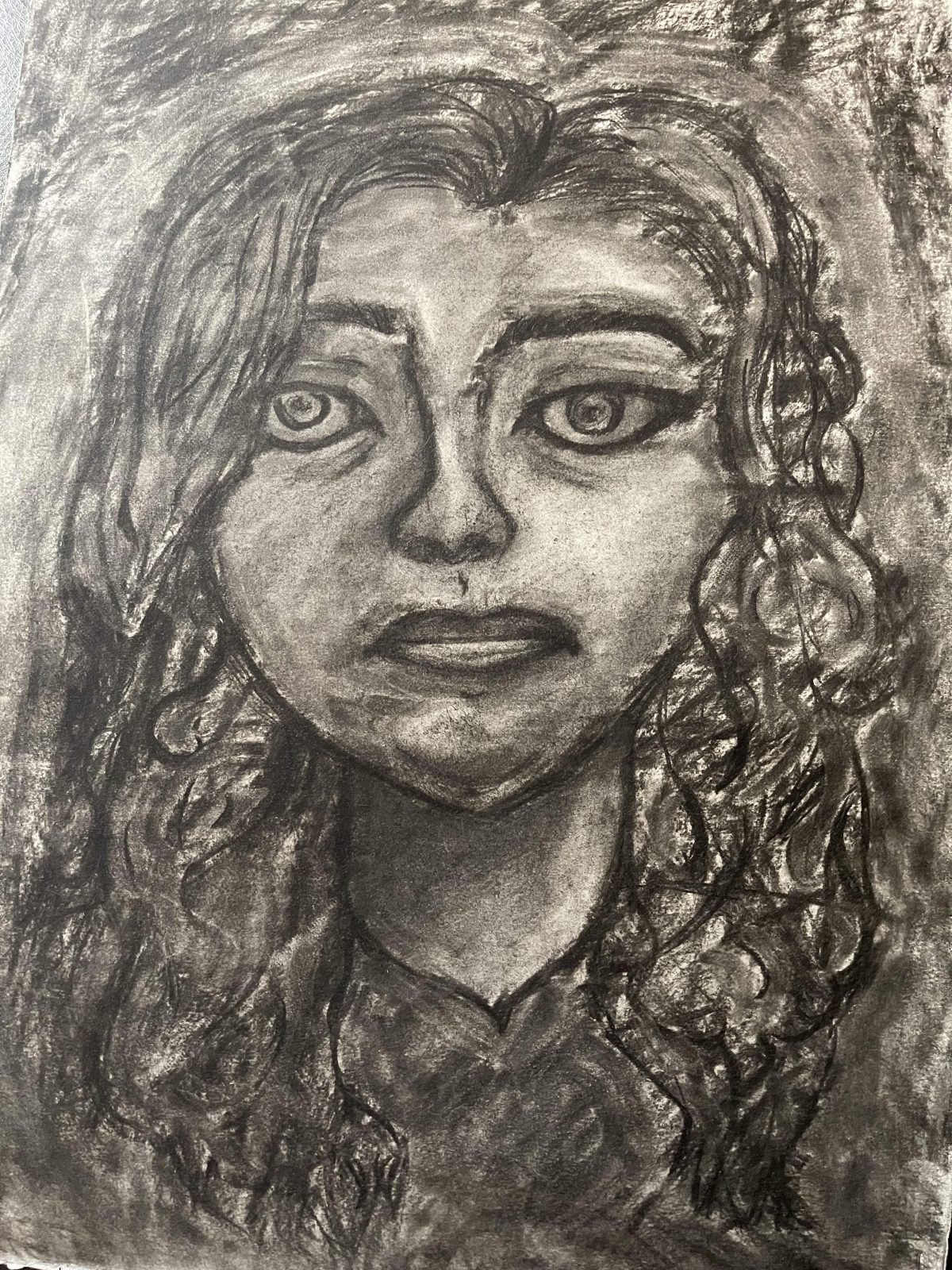 portrait of person with curly hair looking at viewer
