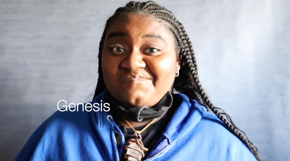 Picture of a person wearing a blue sweater and the word "genesis"