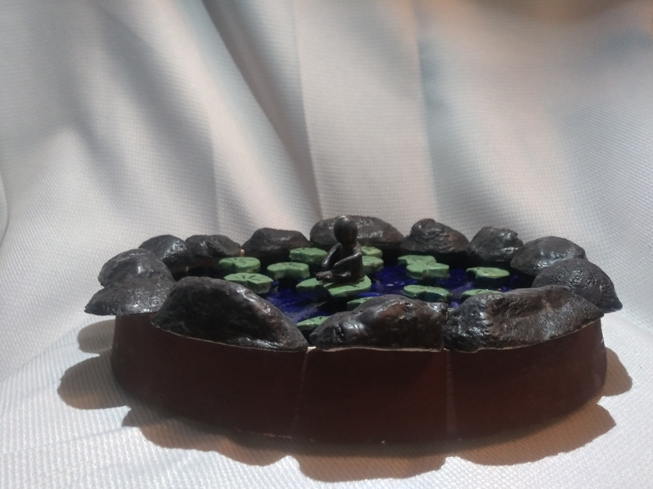 ceramic sculpture of a pond with green lily pads