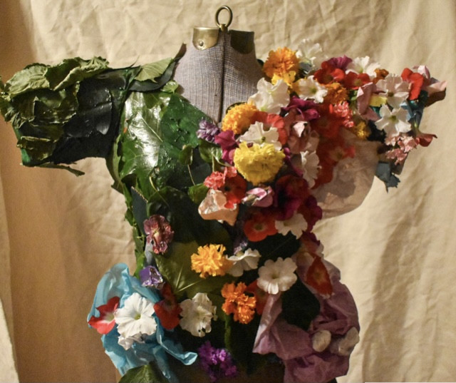 dress that is constructed out of leaves and flowers on a mannequin