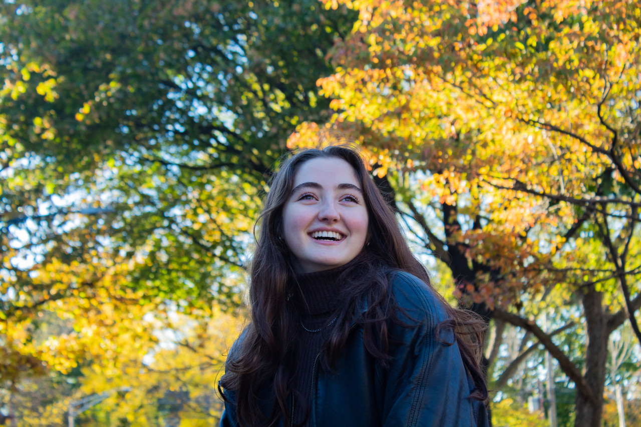 Photograph of a girl in front of trees