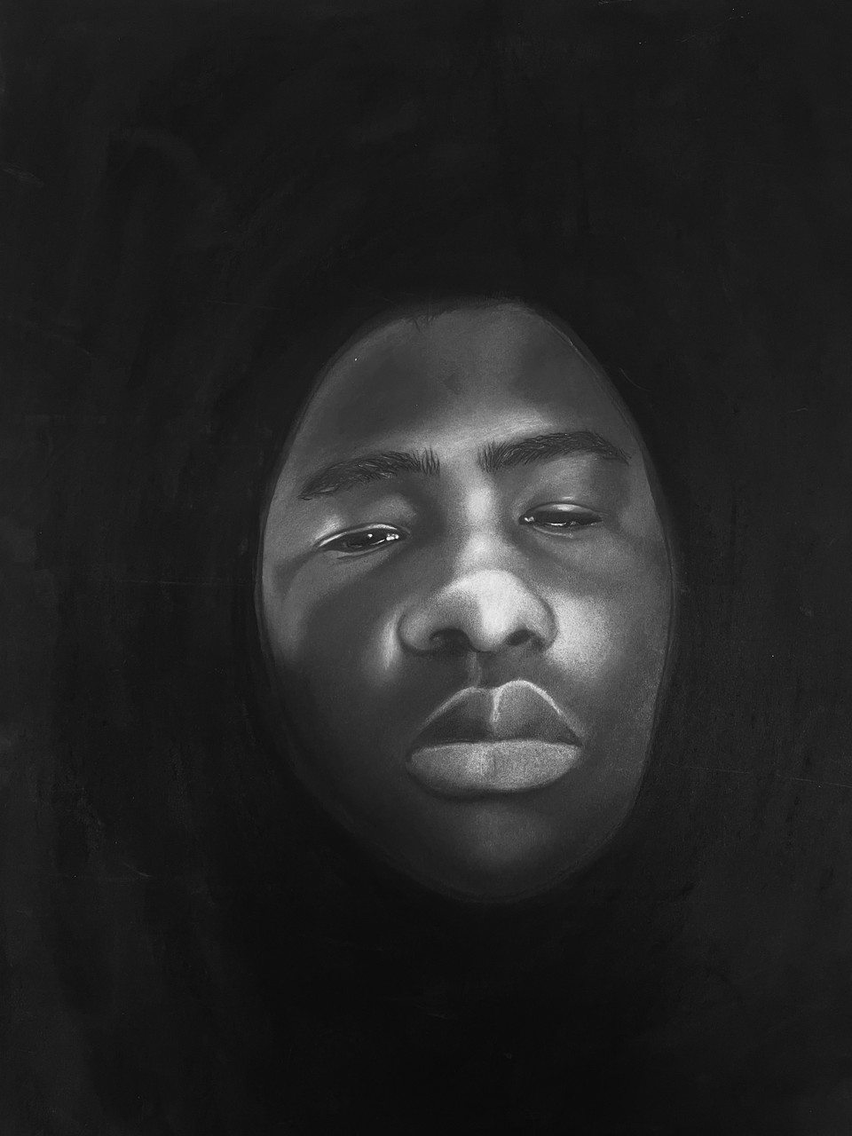 Charcoal drawing of black figure's face floating in black liquid