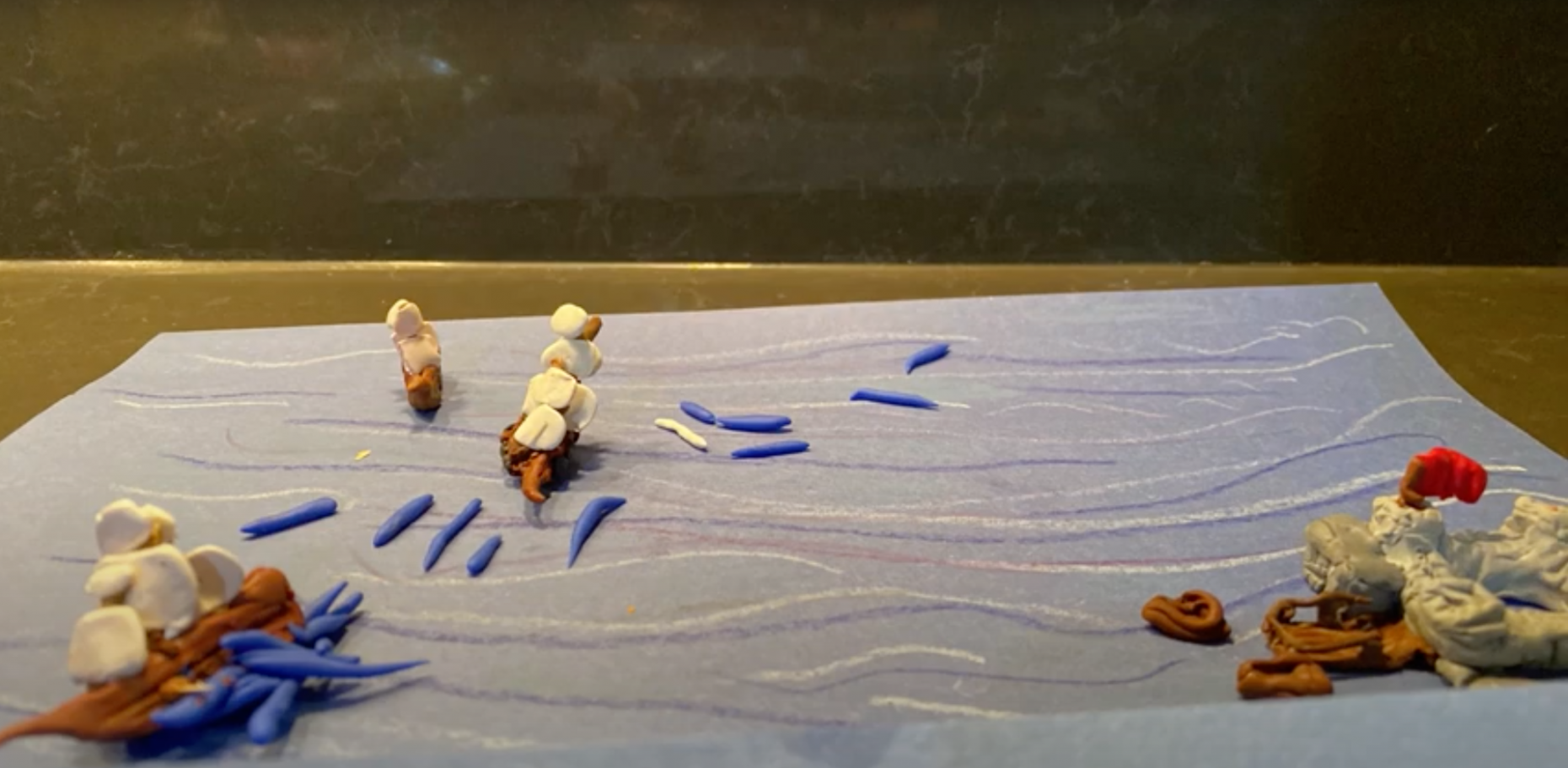 Clay boats on a piece of paper in front of a black background