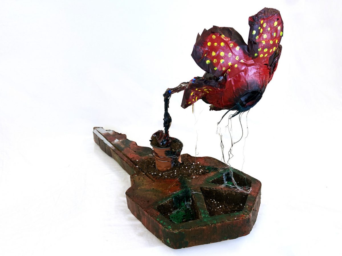 a key with a wilted flower growing from it