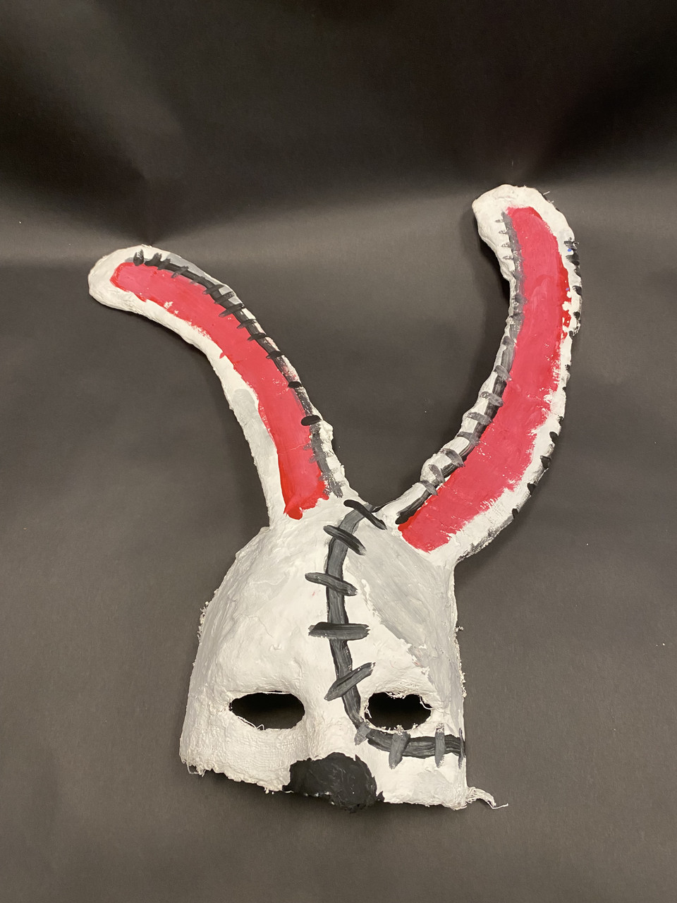 Mask with large pink ears and stitches down the front.
