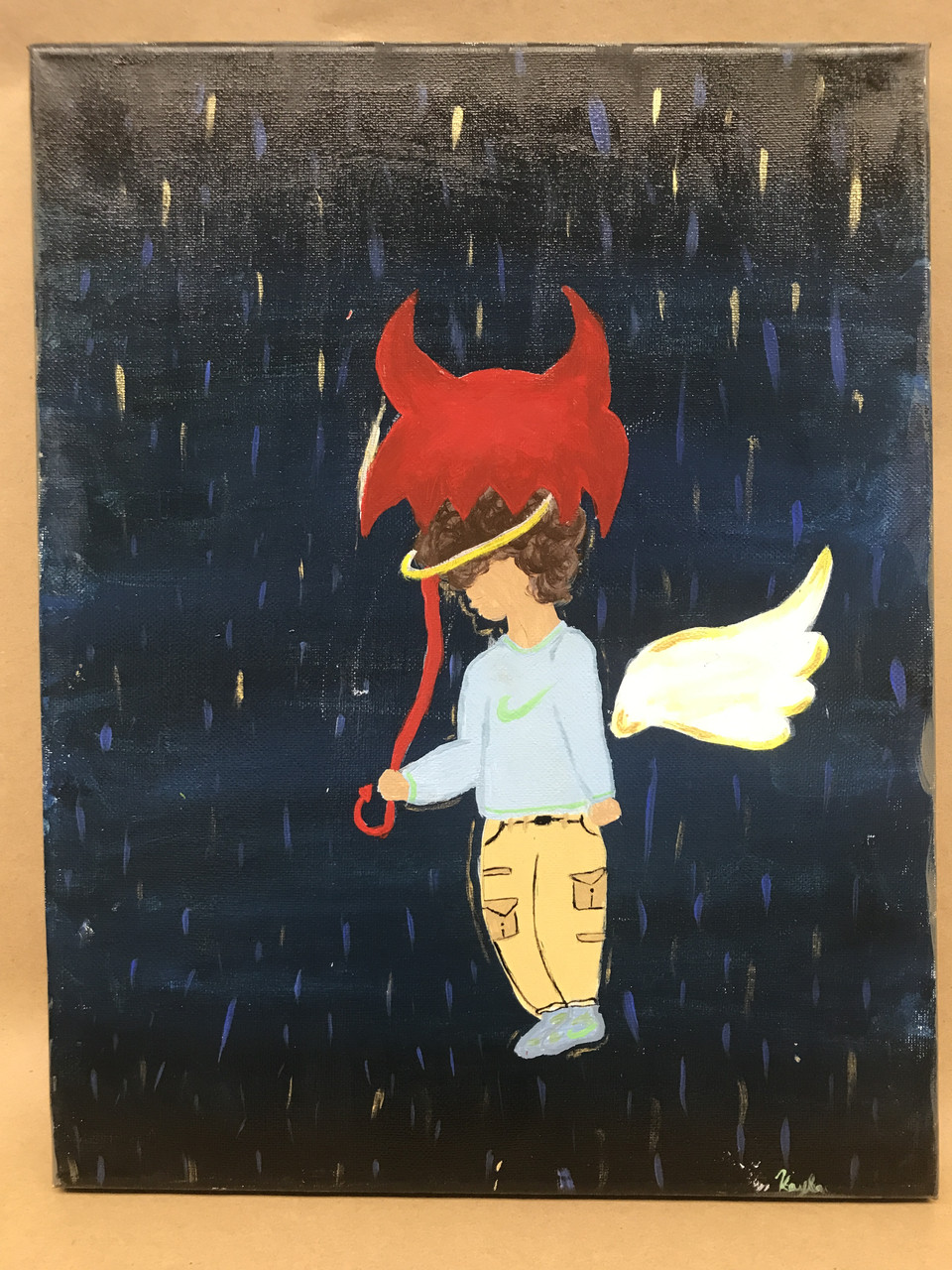 Figure in street clothes with angel wings, halo, holding umbrella with devil horns & tail