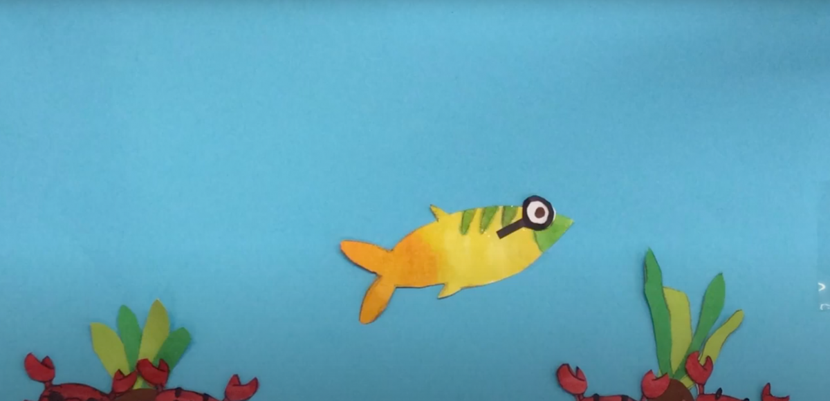 Cut paper fish swimming on a blue background