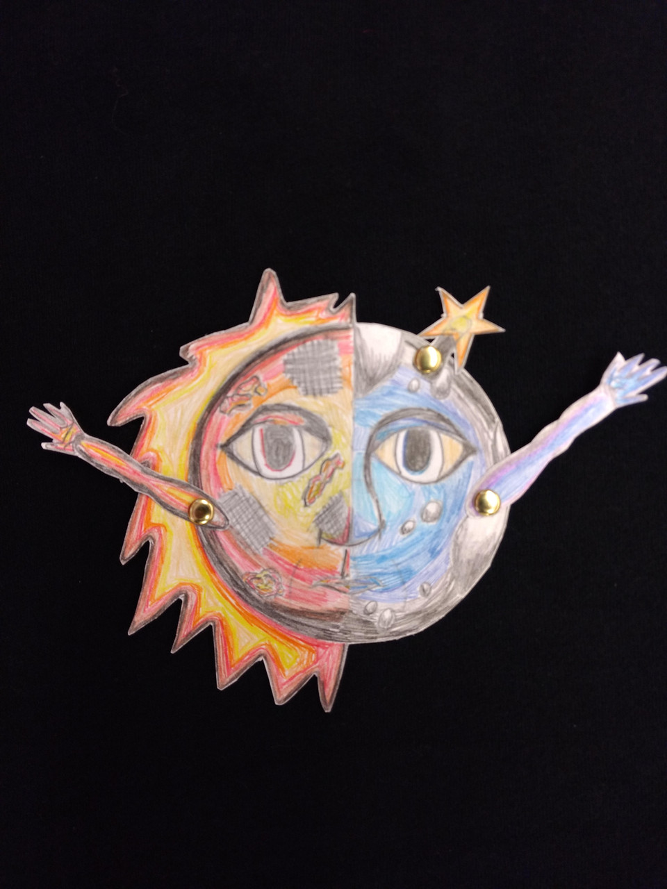 paper cut out of sun and moon, divided down the middle with additional moving arms