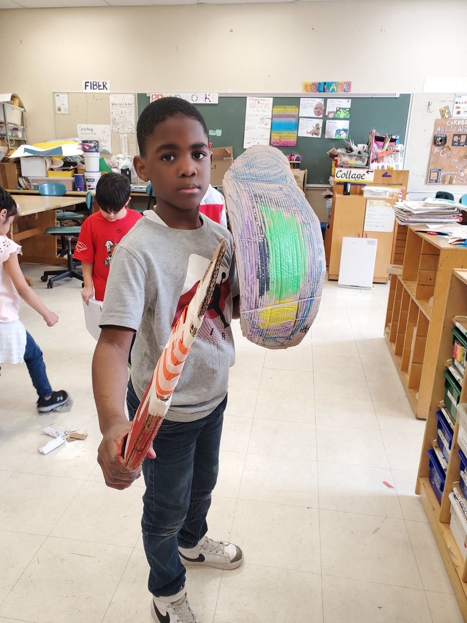 boy holding his sculpture of shield and sword