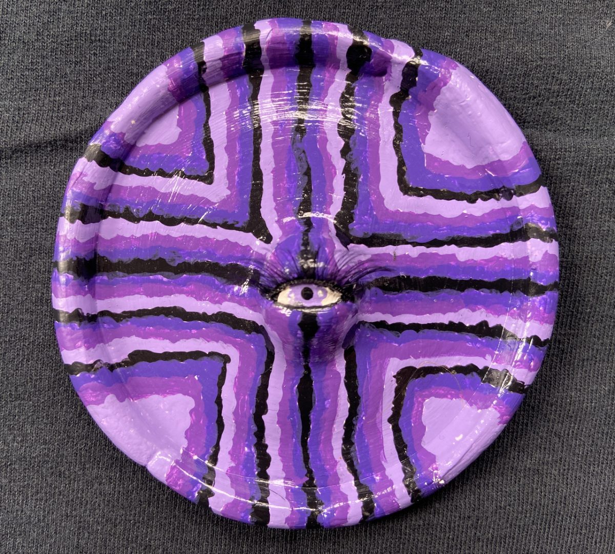 purple scuplture of an eye on a plate