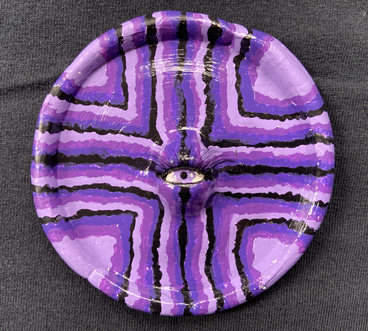 purple scuplture of an eye on a plate