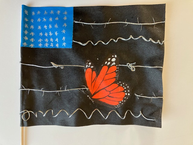 A flag with black and blue that depicts barbed wire and a butterfly/