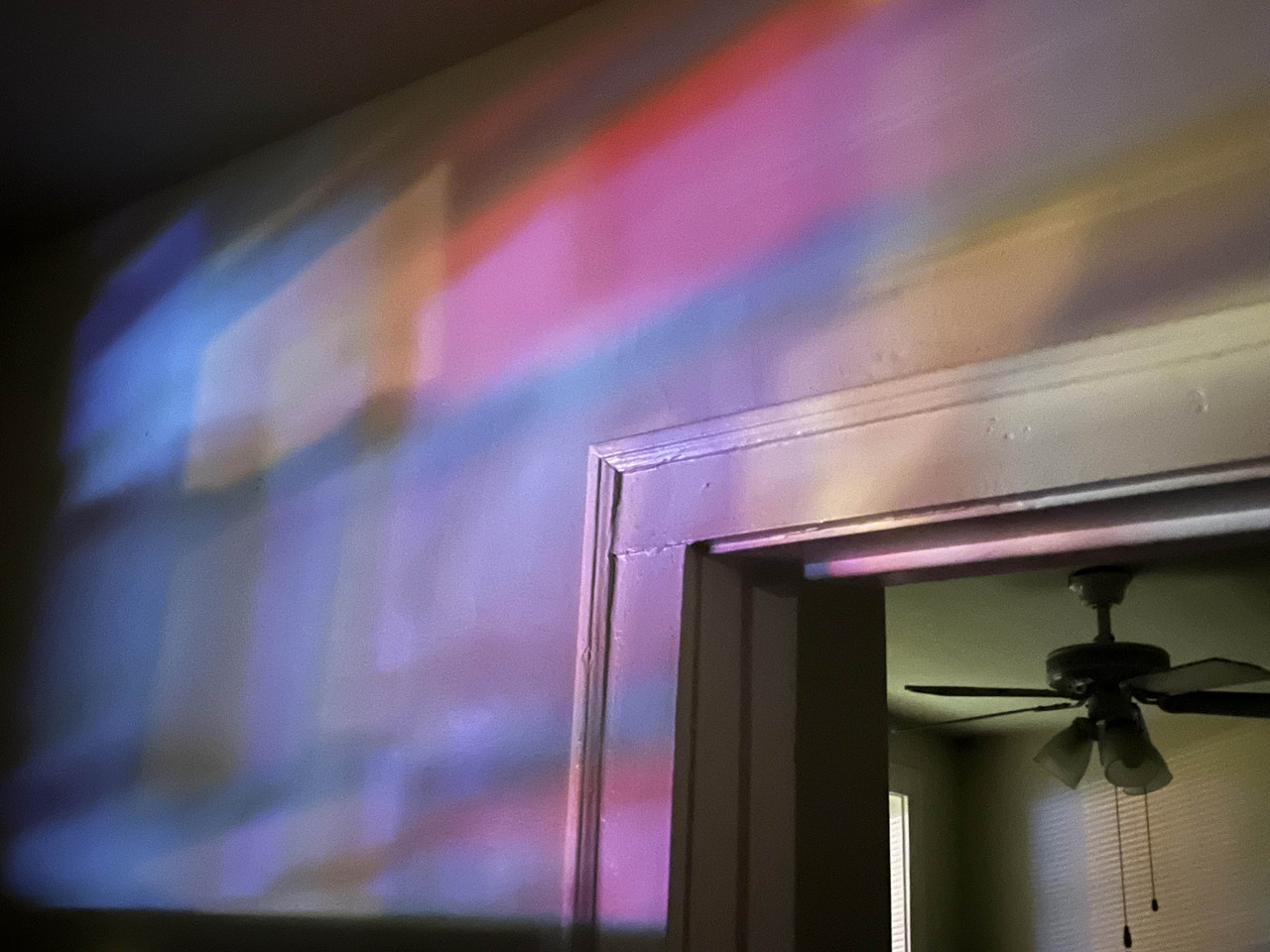 Photo of an interior room with a multicolored light on the wall.