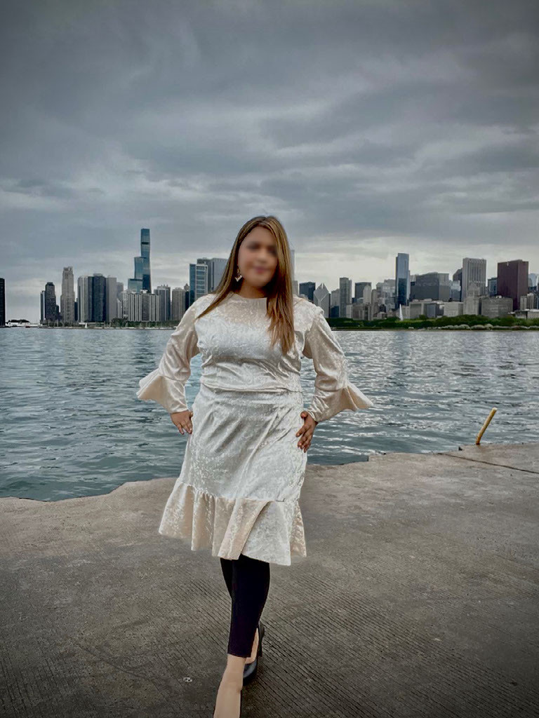 A person wearing a white dress with the Chicago skyline in the back.