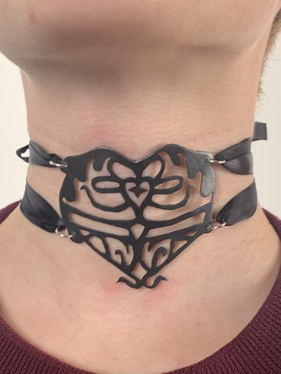 Picture of a black metal heart shaped choker.