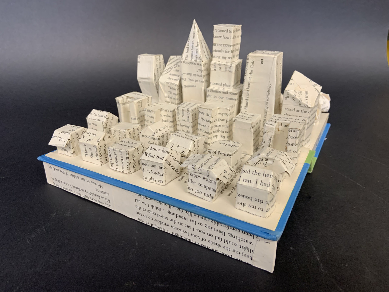 Sculpture of a cityscape made out of the pages of a book