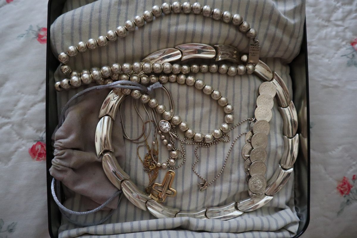 An open case filled with silver metal jewelry