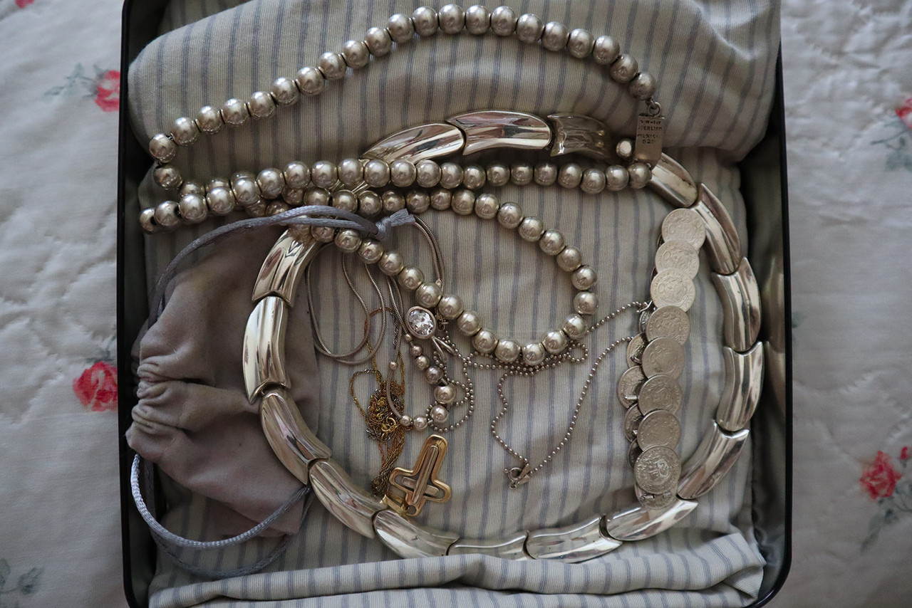 An open case filled with silver metal jewelry