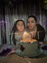 2 people blowing out candle