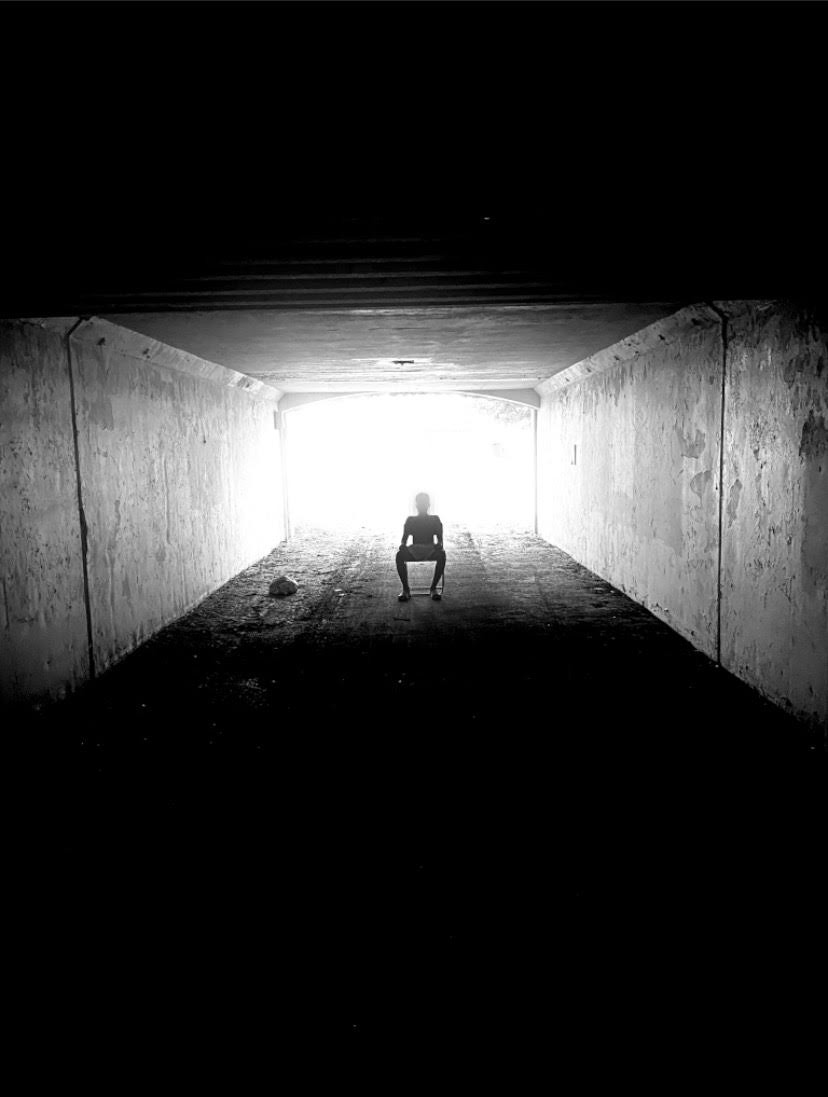 Black and white: Figure sitting in an illuminated room