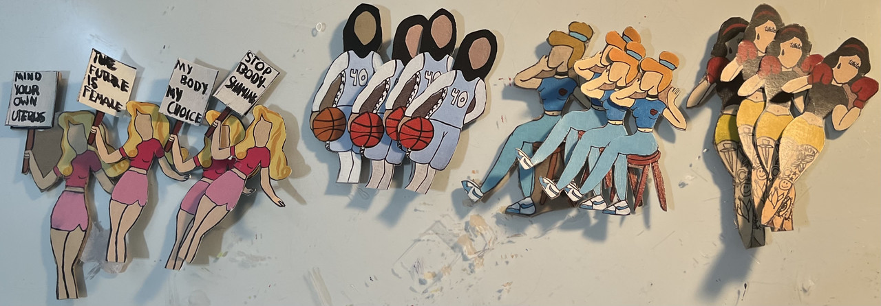 Small figures, in groups of identical fours, are sculpted out of card stock. They are modeled after well known Disney princesses turned into feminists.