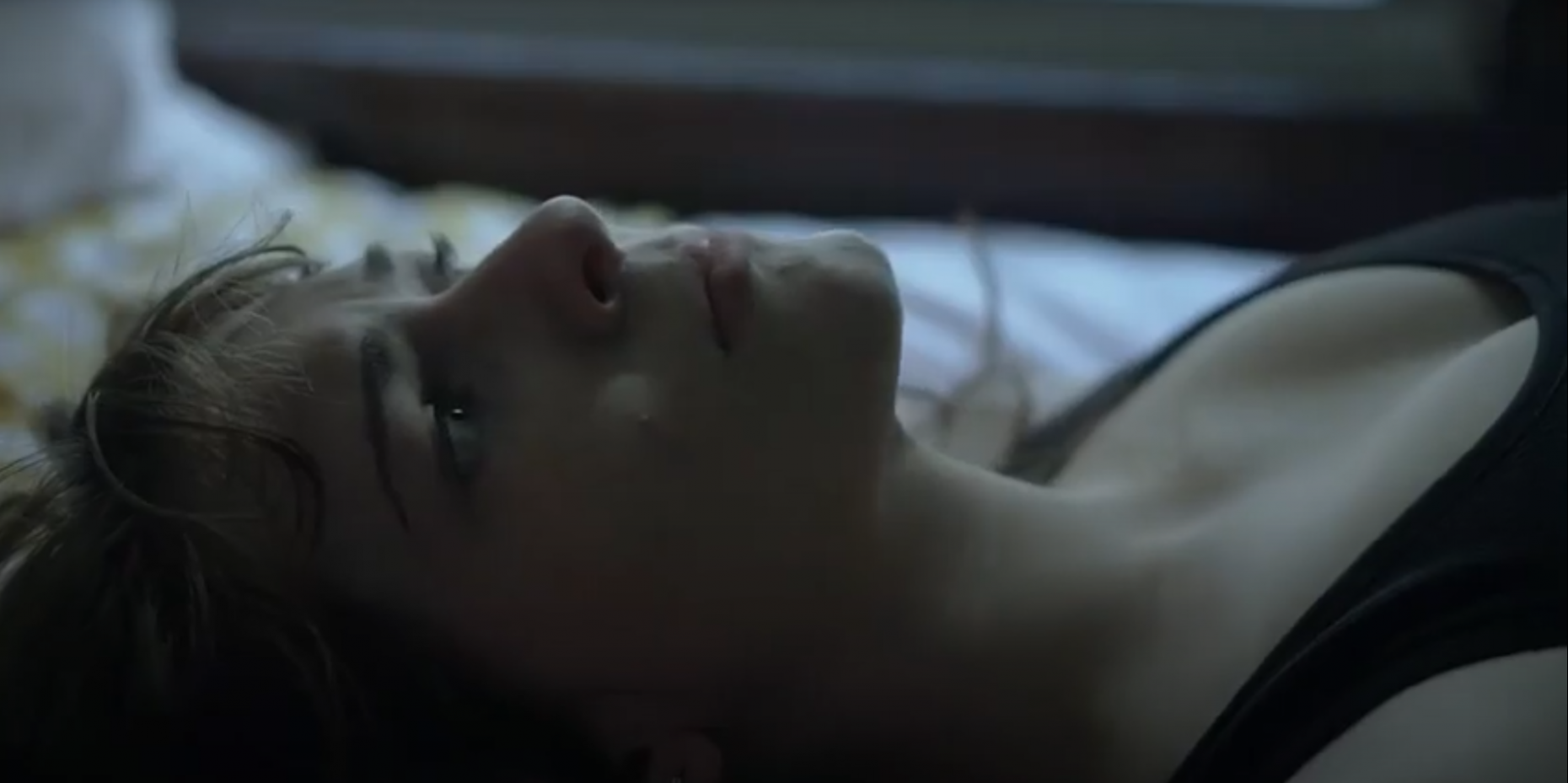 Person laying flat on a bed looking up