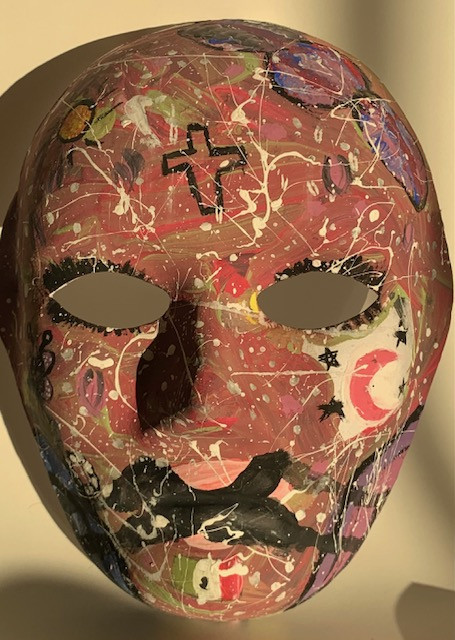 Paper mache mask with symbols, patterns, and colors on it.