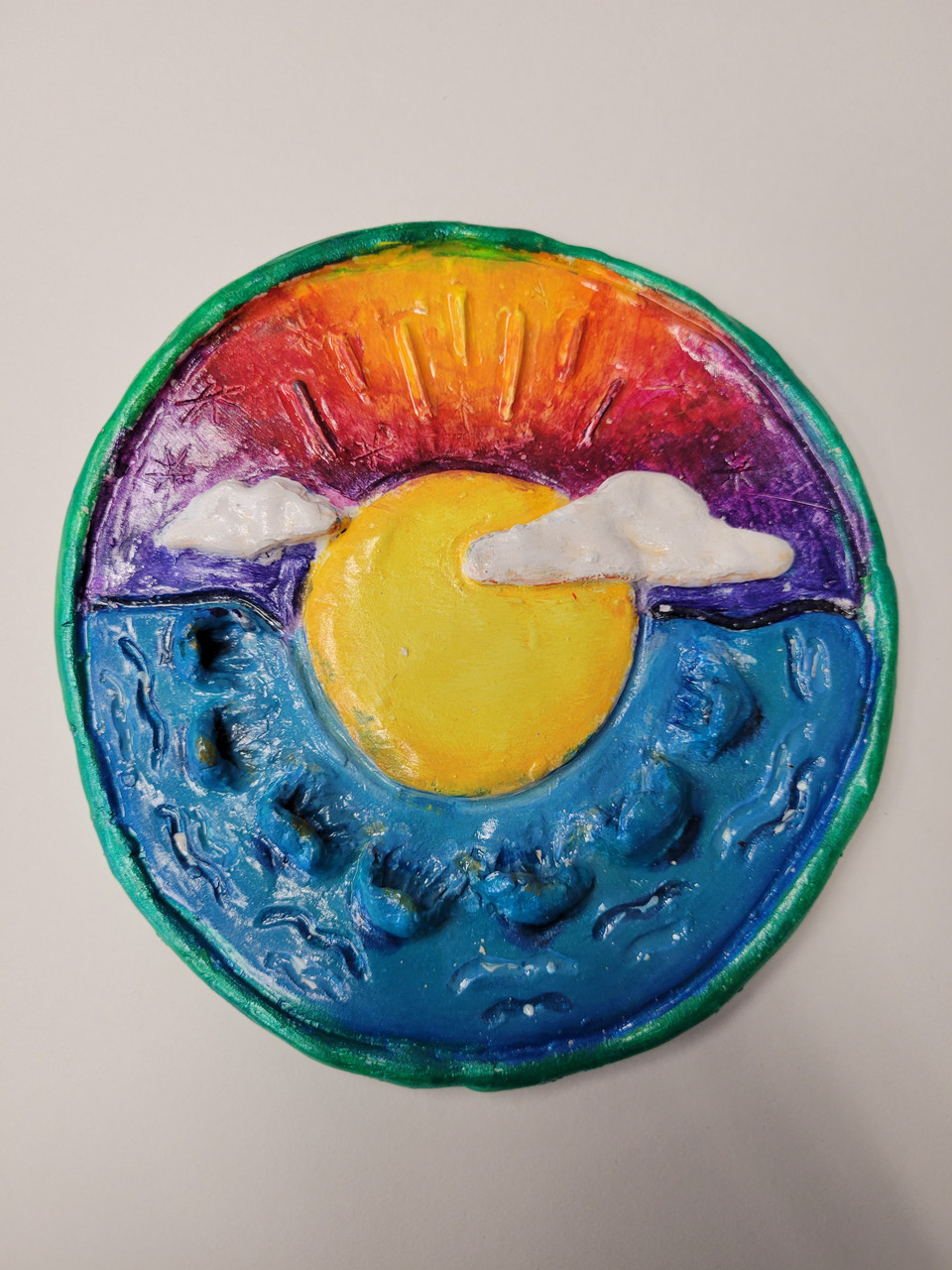 Sculpture of a sunset over water.