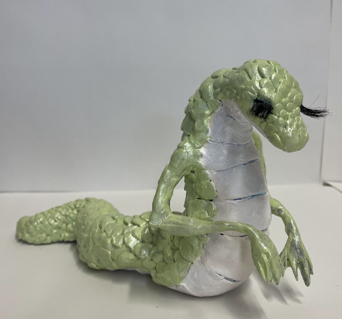 Sculpture of a lizard like character.