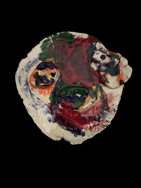 Ceramic face with painted colors.