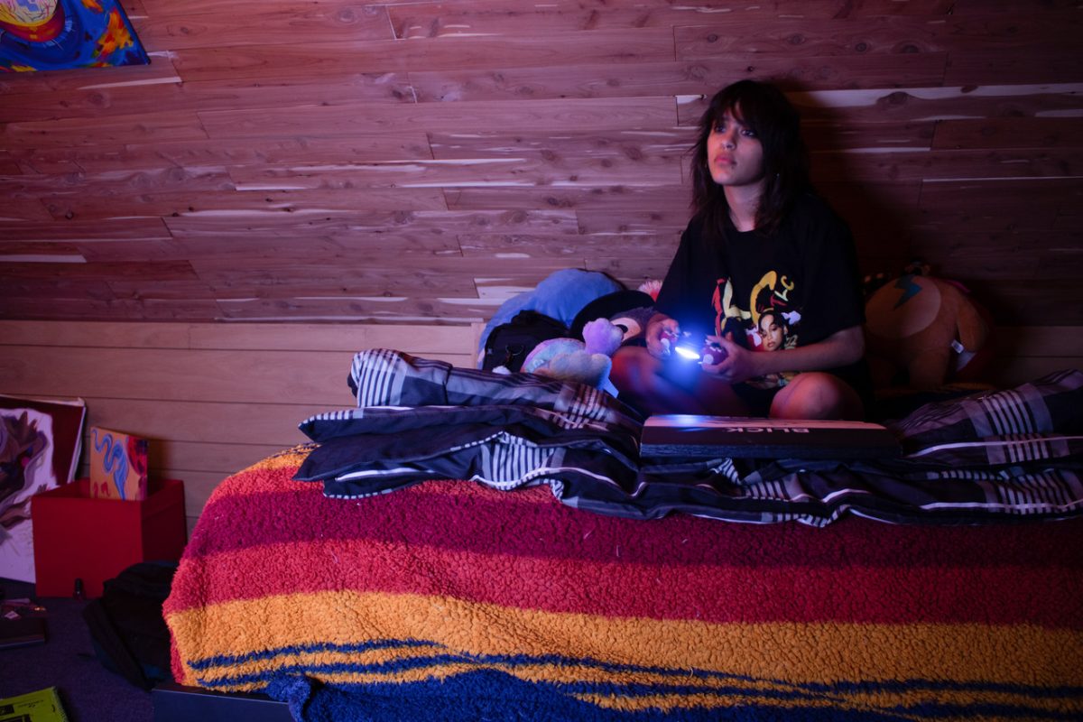 Picture of a person sitting on a bed.