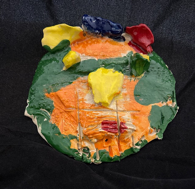 Ceramic face painted with various colors (orange, green, yellow, red, and blue).