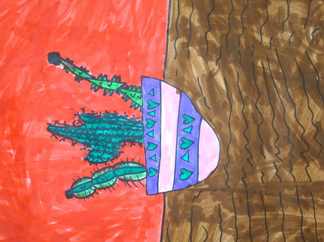 A succulent sits in a purple and pink pot on a brown surface in front of a coral background.