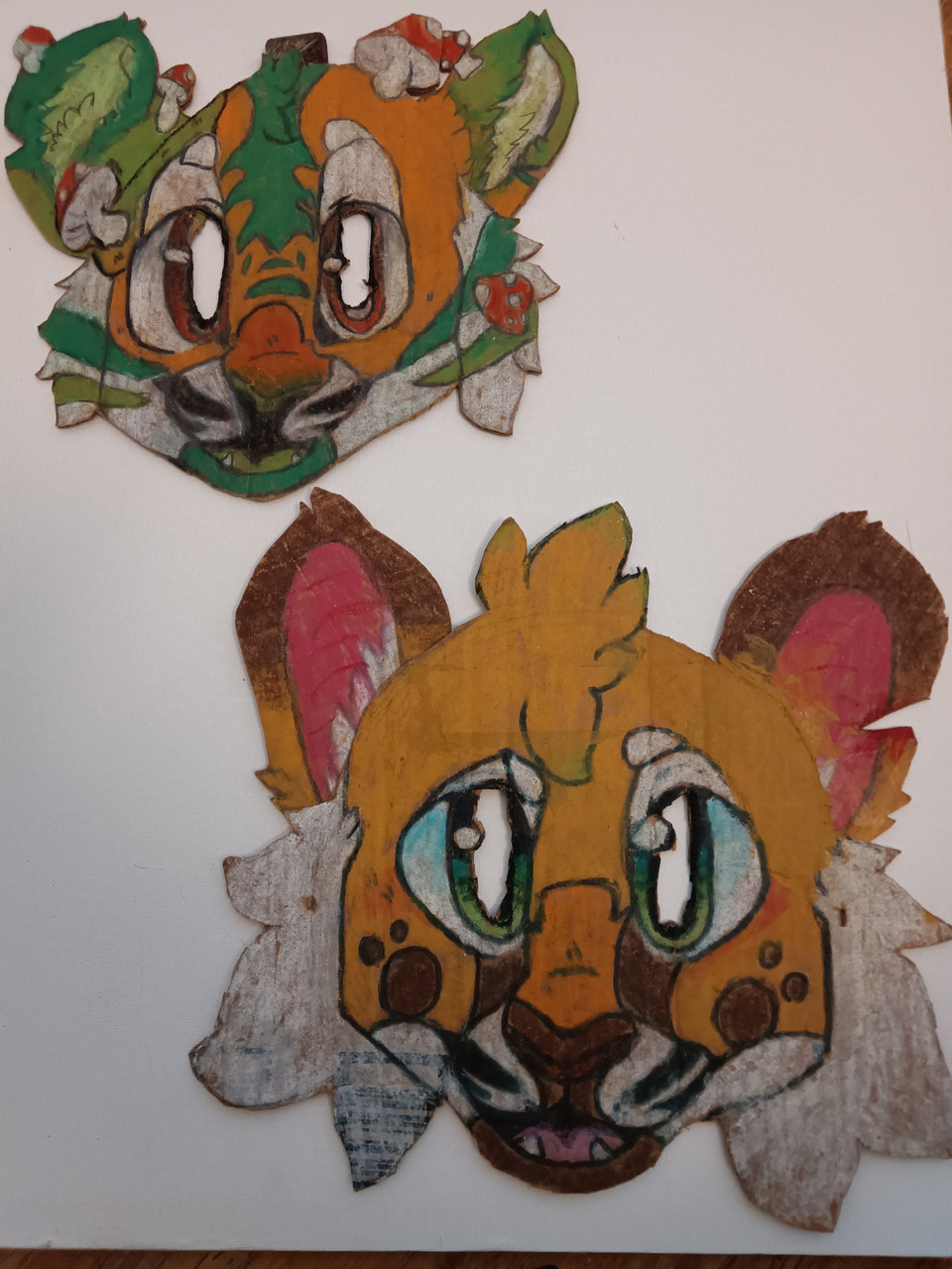 2 heads of tiger-like animals with blue eyes and orange fur