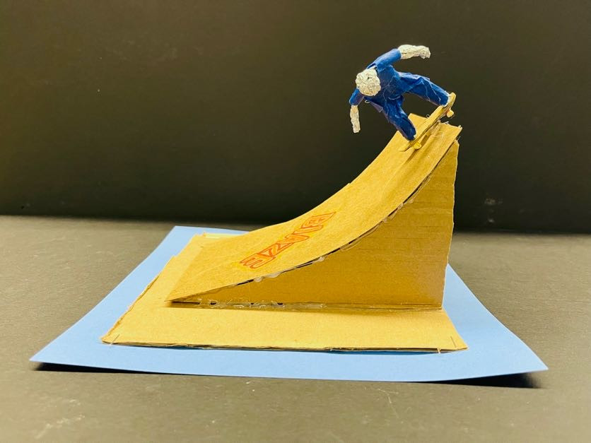 Sculpture of a skateboarder on a ramp.