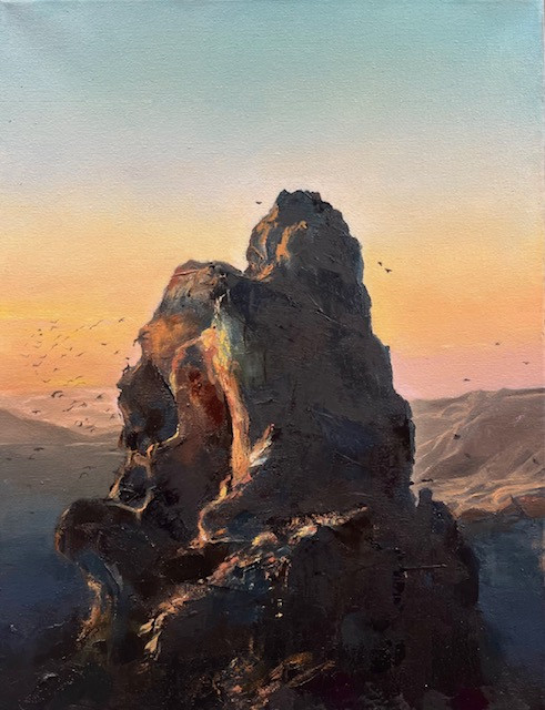 large rock formation against a sunset or sunrise