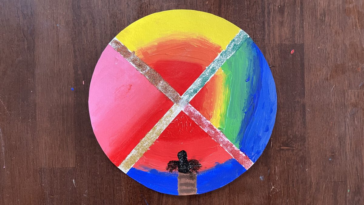 Blue, pink, red, and yellow sunset is painted on four quadrants of cardboard.