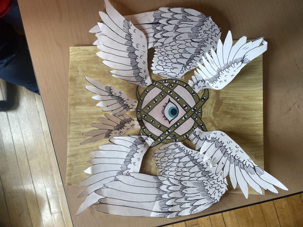 Paper artwork depicting wings and an eye.