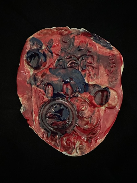 Ceramic face painted with red and black.