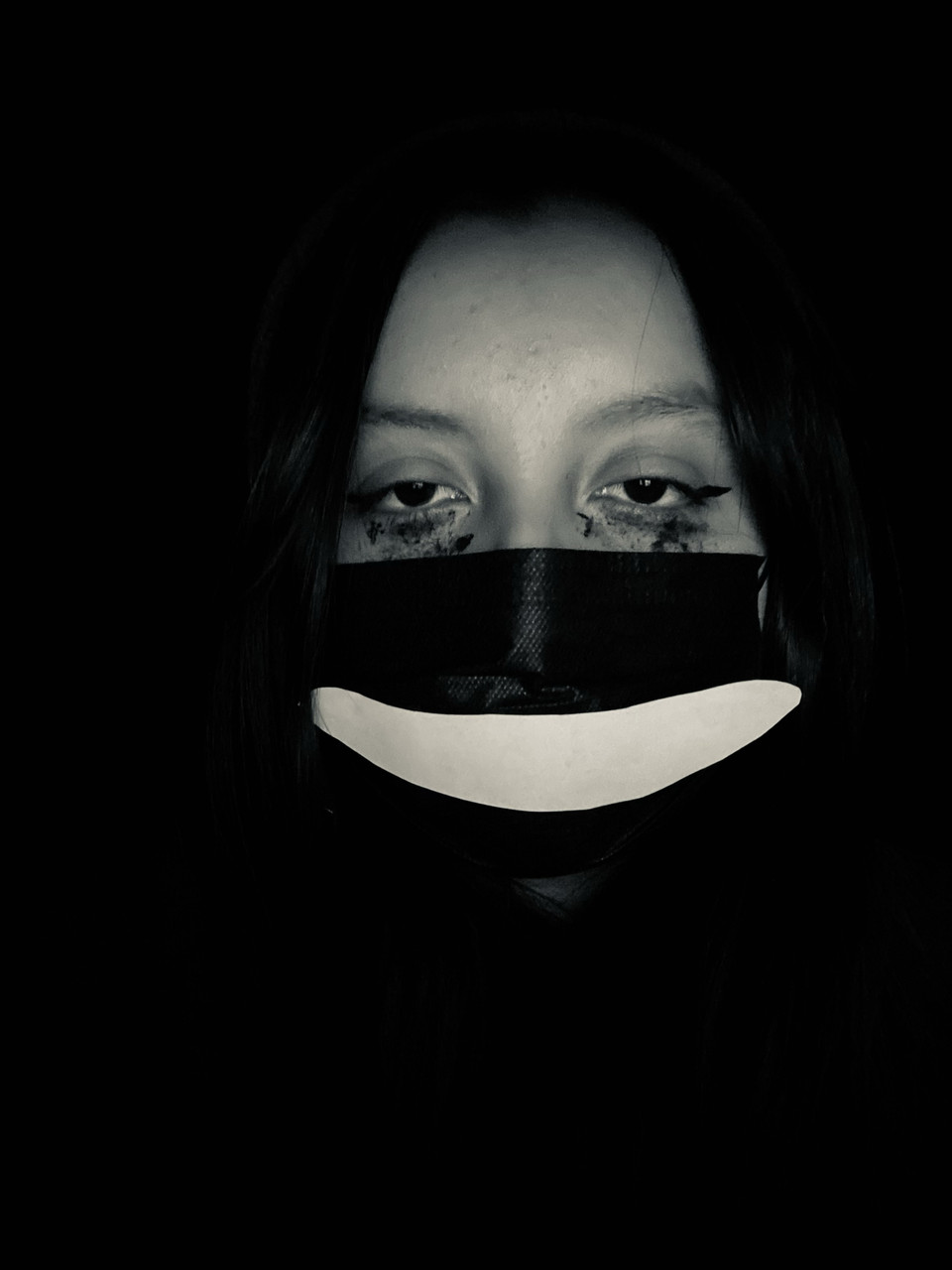 Black and white photograph of a sad person with a mask.