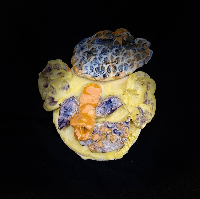 Colorful sculpture of a face with textures on it.