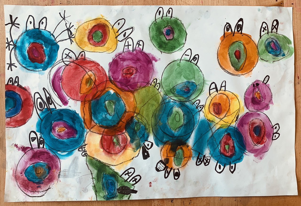 Circles made with colorful watercolors are turned into characters with eyes. The circles are all over the page and overlap.