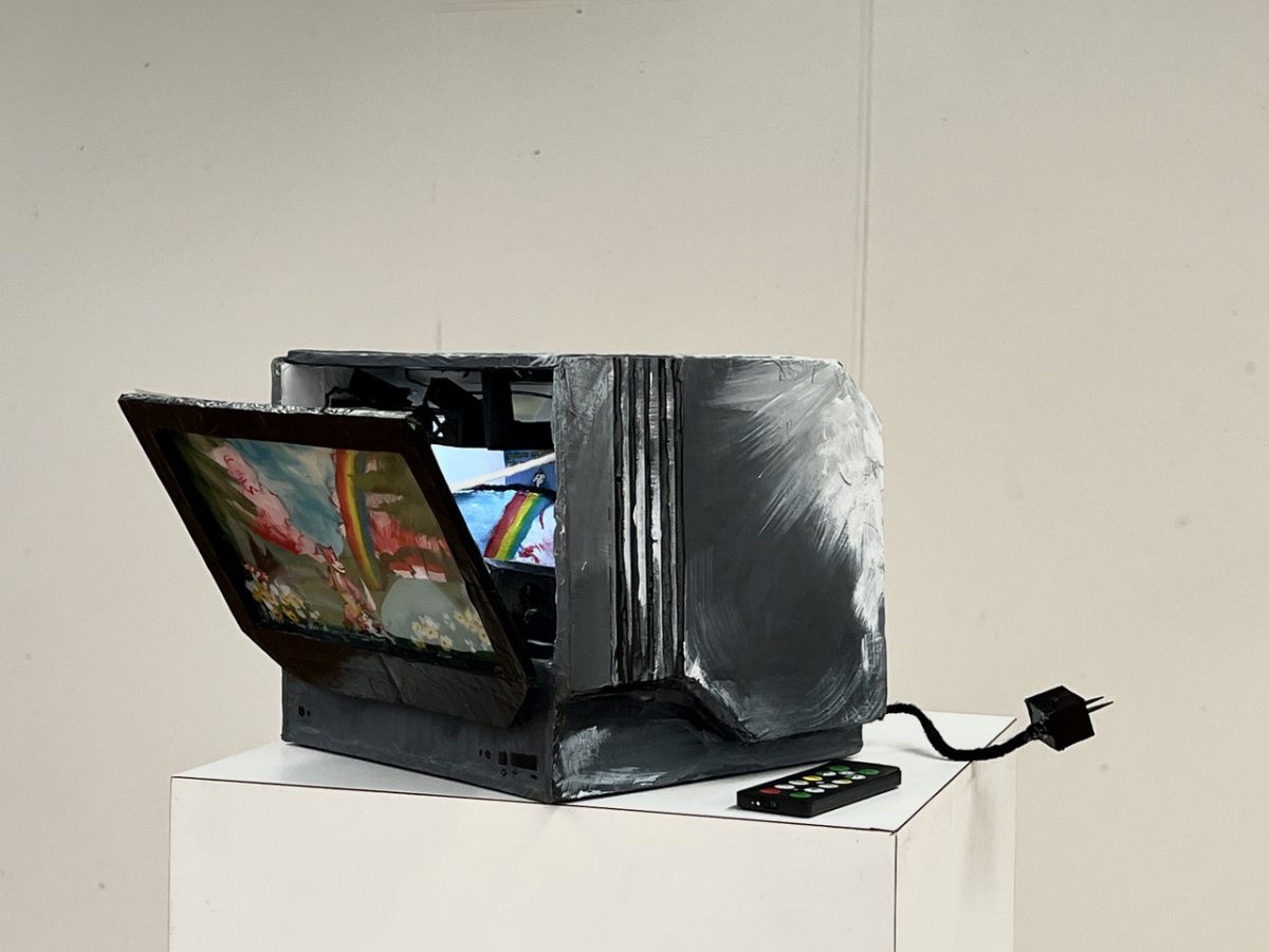 Three dimensional piece of a TV with a chord and remote. The TV screen is opened up with visuals inside of the TV box.