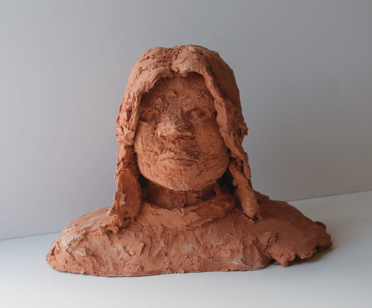 A bust of a woman with medium length hair.